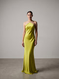 Woman wearing a bright lime evening gown against a plain background